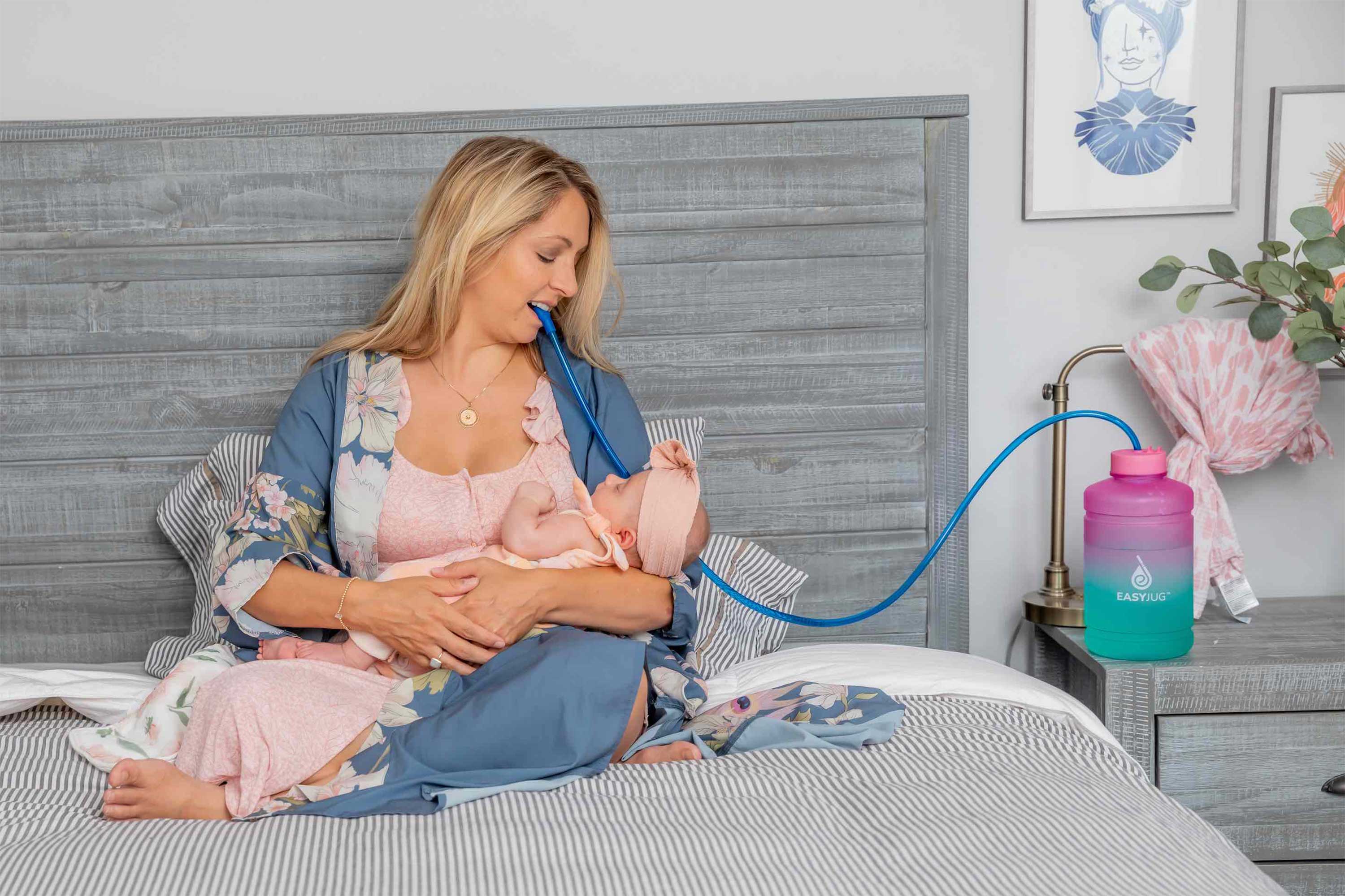 Mom breastfeeding her daughter while drinking water from her EasyJug Water Bottle