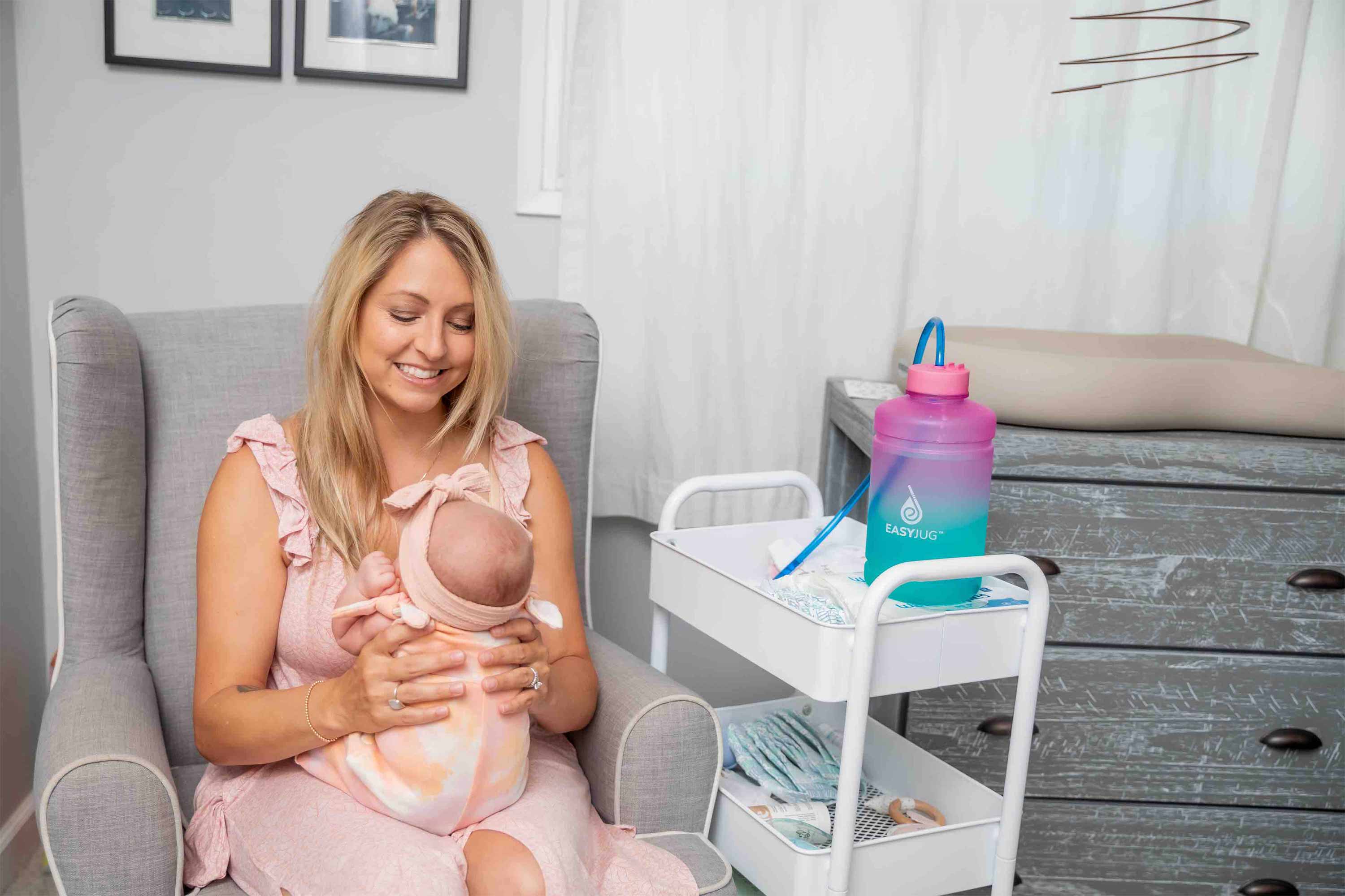 Breastfeeding Mom playing with her Baby in Nursery Room with her EasyJug Water Bottle